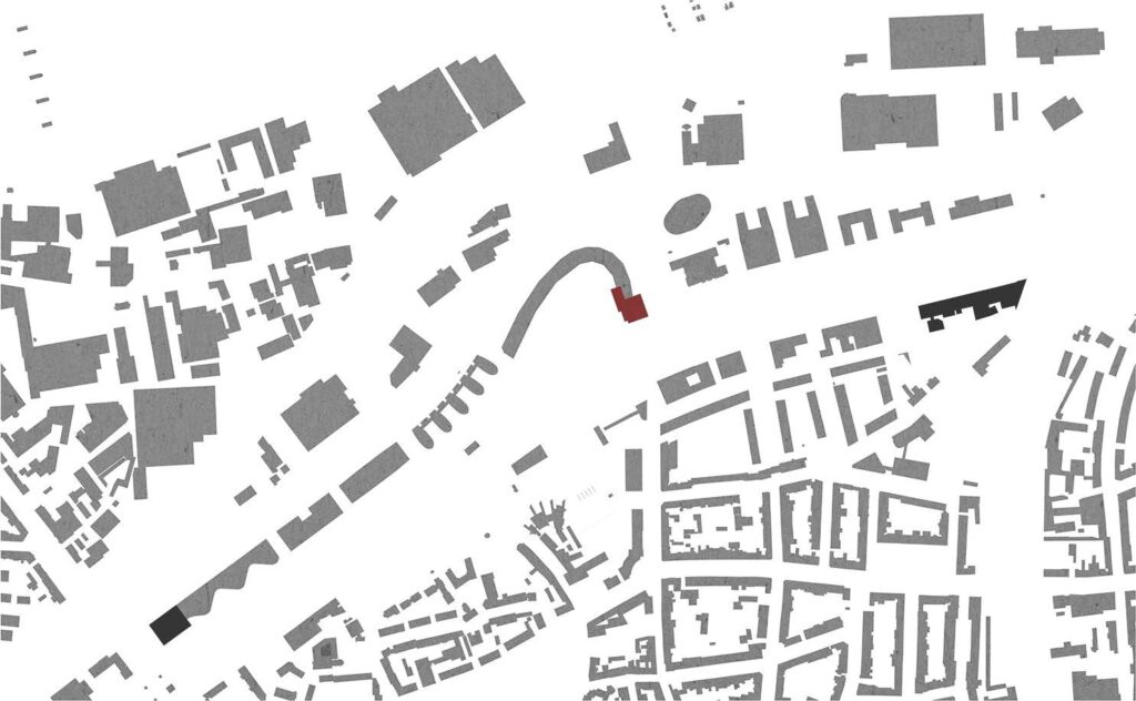 Eine Architekturkarte in Graustufen mit abstrakten Gebäudeformen. Zwischen den grauen Strukturen ist eine rote Form hervorgehoben, die eine Hervorhebung oder einen interessanten Punkt darstellt.